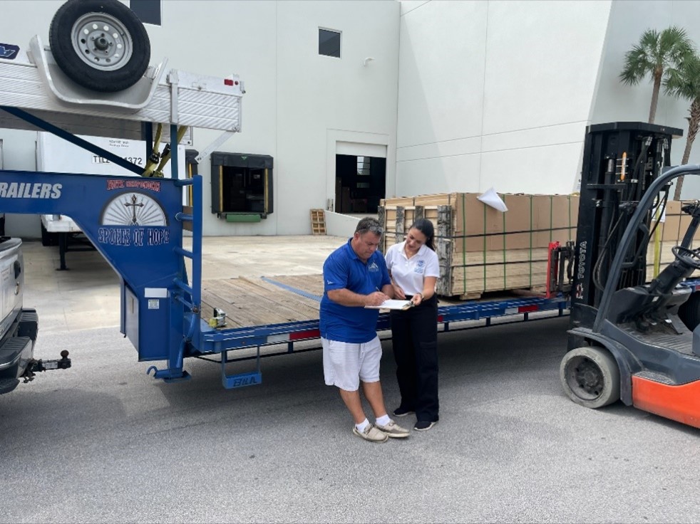 Spokes of Hope founder and director Shane Zoccole receives donated plywood from CBP’s Amelia Castelli.