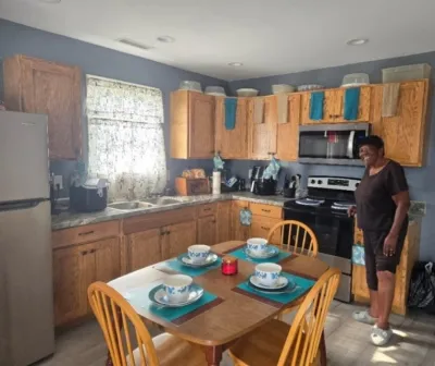 Hazel Cropper enjoying her new kitchen cabinets built with donated plywood from CBP.