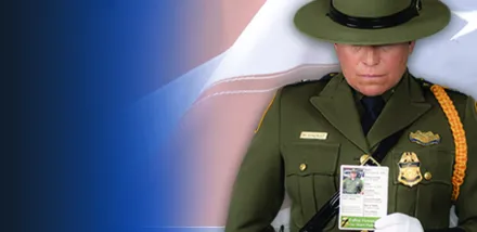 A Border Patrol agent holds the Silent Partner card of a fallen agent.