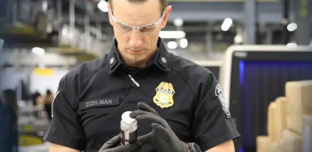 Chief Supervisory CBP Officer Eric Zizelman examines the contents of an express cargo shipment at the Port of Cincinnati